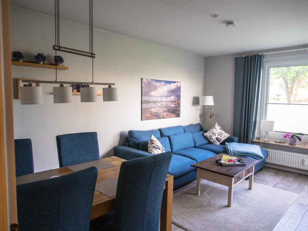 グリュックスブルクにあるFEWO Muschelのリビングルーム(青いソファ、テーブル付)
