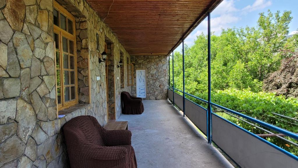 a porch with two chairs and a stone wall at Sofia in Vardzia