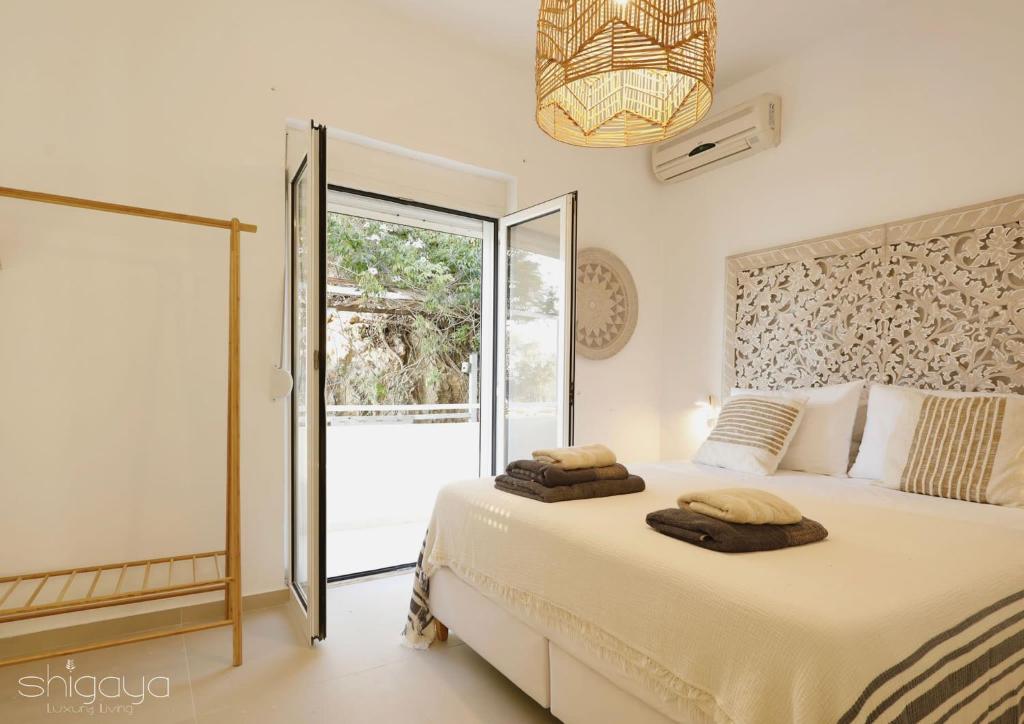 a bedroom with a bed with two towels on it at SHIGAYA Boutique Villa in Plaka