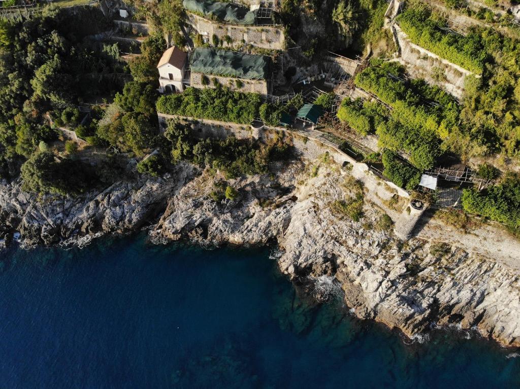 an aerial view of a house on a cliff next to the water at Bella Baia Relais in Maiori