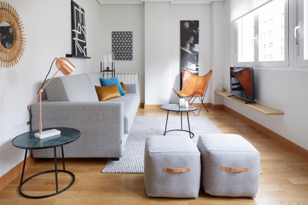 a living room with a couch and two ottomans at Mundaiz by FeelFree Rentals in San Sebastián