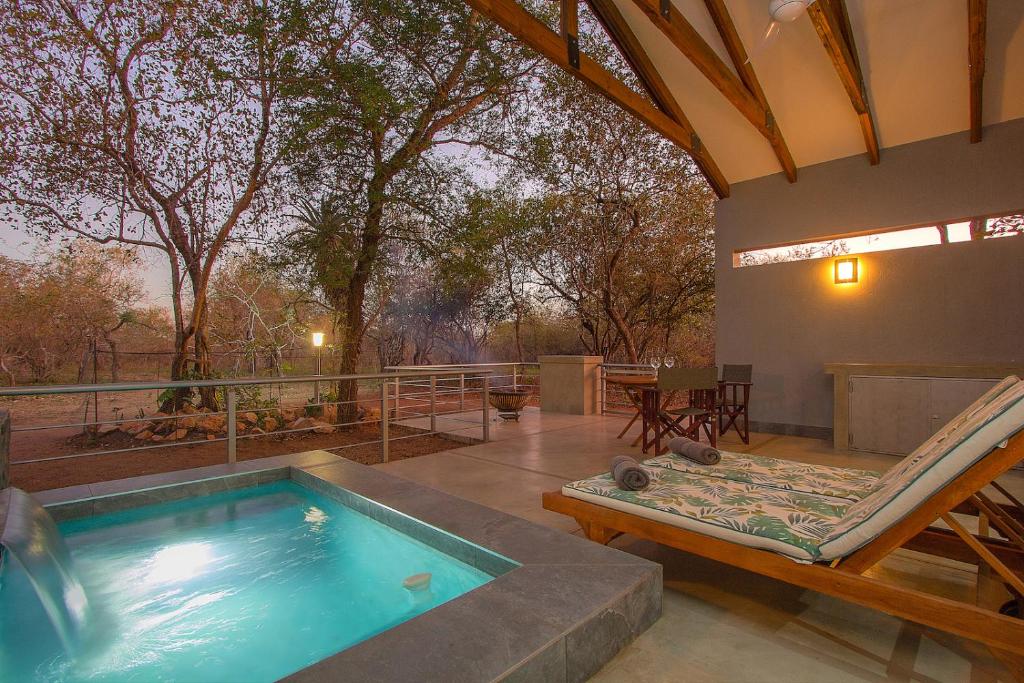 una casa con piscina e patio di Kruger's Keep - Luxury Couples Haven a Marloth Park