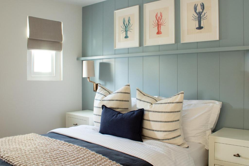 a bedroom with a bed with blue and white pillows at Richardson Apartment in Aberaeron