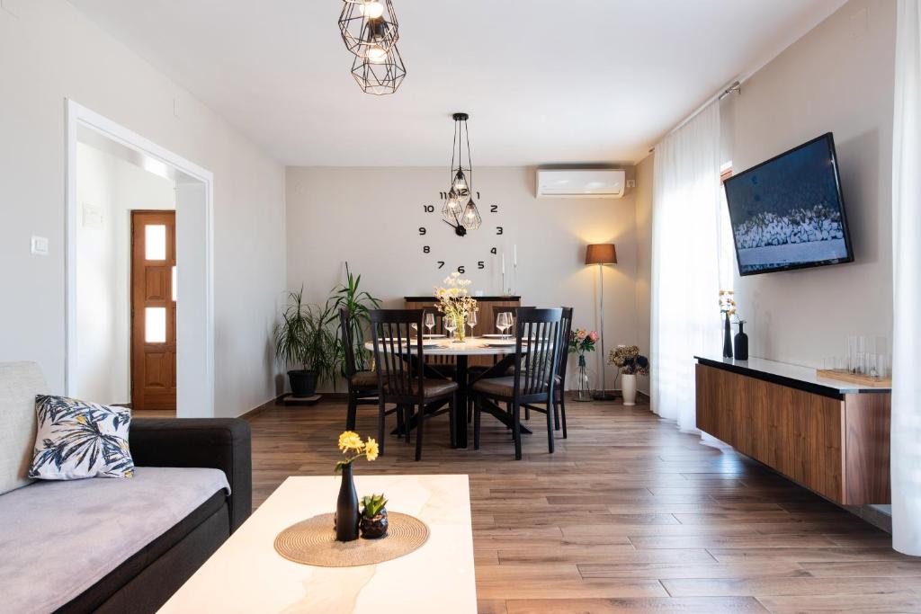 a living room and dining room with a table and chairs at Superior Apartment Sincic in Poreč