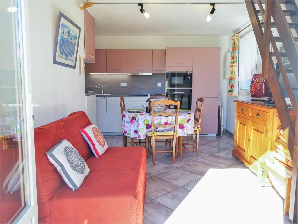 a living room with a red couch and a table at Apartment Les Romarines-5 by Interhome in Gruissan