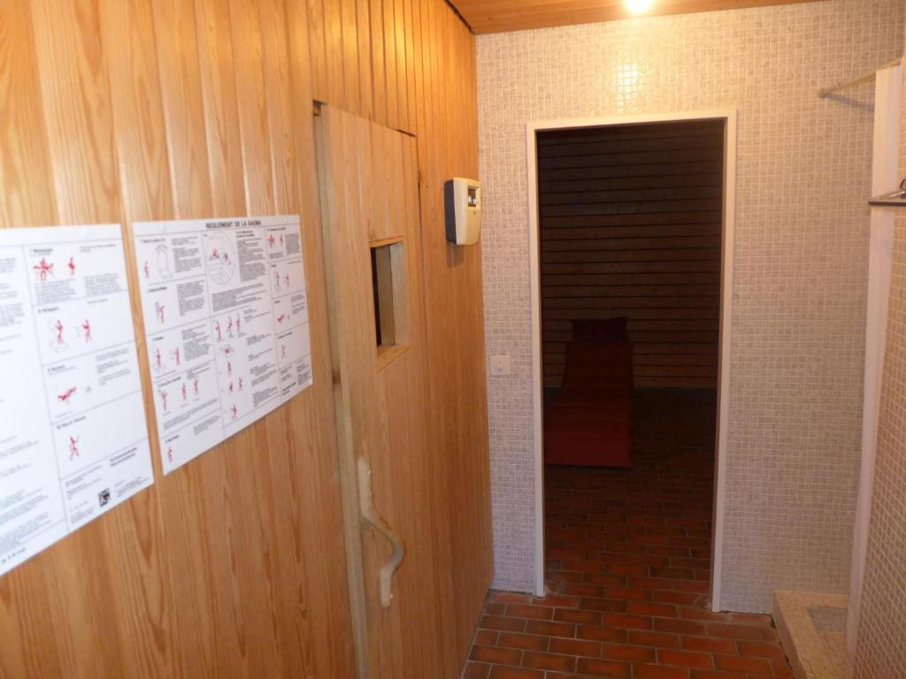 a hallway with a door and a wall with papers at Apartment Jeanne D'Arc Apt- C-28 by Interhome in Crans-Montana