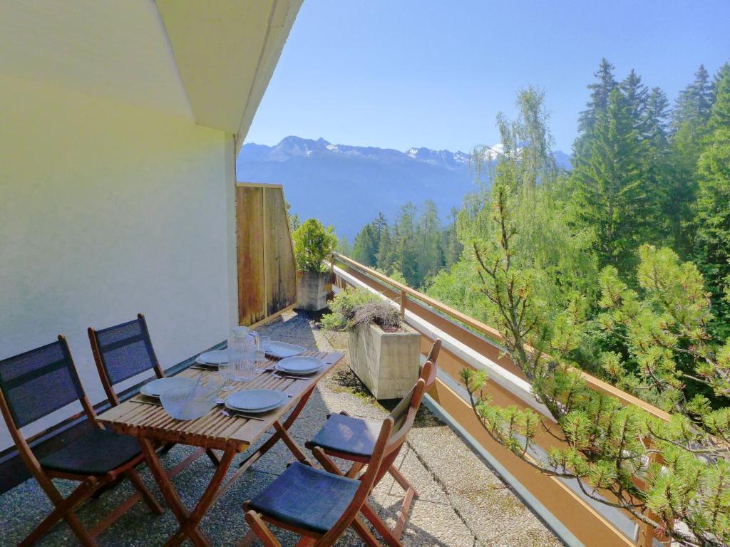 einen Tisch und Stühle auf einem Balkon mit Aussicht in der Unterkunft Apartment Terrasse des Alpes-32 by Interhome in Crans-Montana