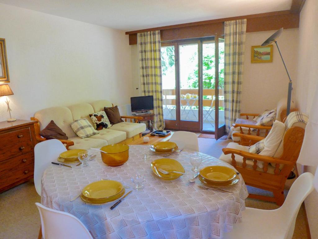 a living room with a table with yellow dishes on it at Apartment Terrasse Des Alpes 3008 by Interhome in Vermala