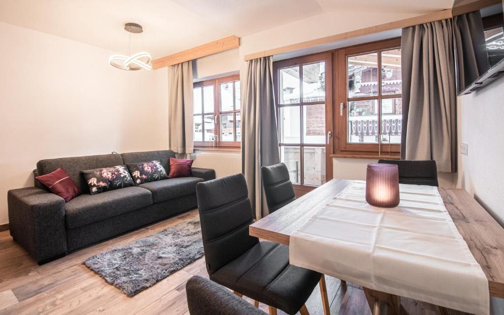 salon ze stołem i kanapą w obiekcie La Tombola Appartements w mieście Gerlos