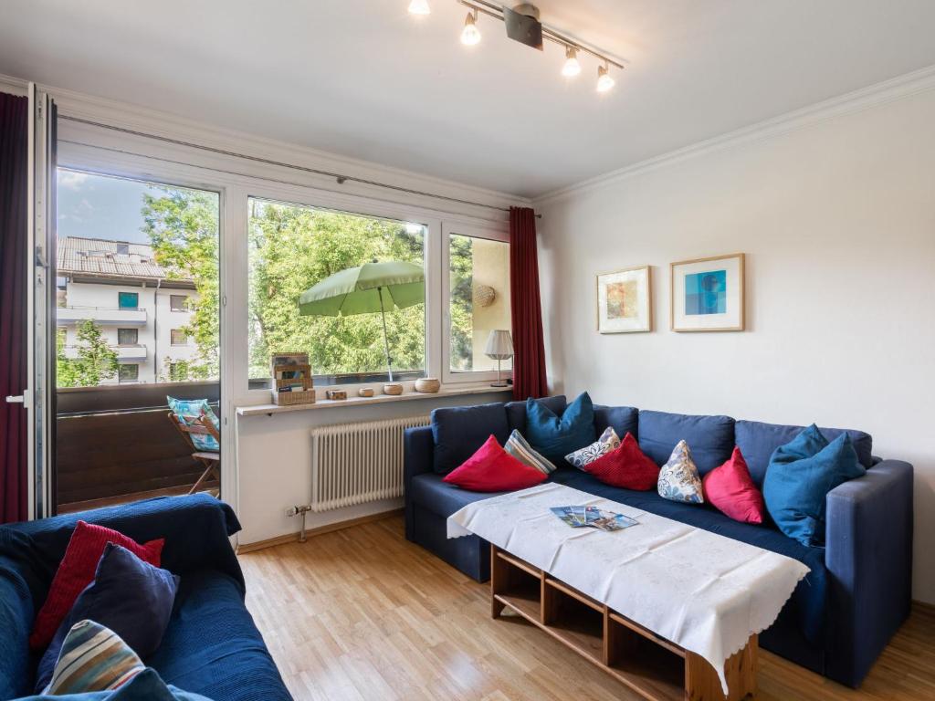 滨湖采尔斯坦萨里公寓的客厅配有蓝色沙发和红色枕头