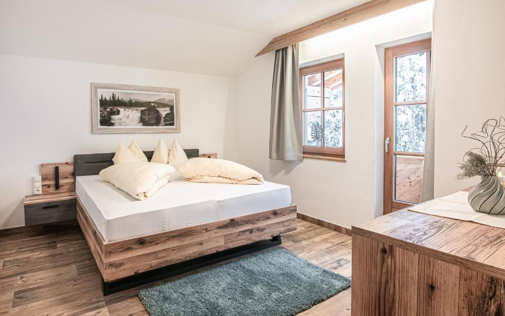 sypialnia z łóżkiem z białą pościelą i poduszkami w obiekcie La Tombola Appartements w mieście Gerlos