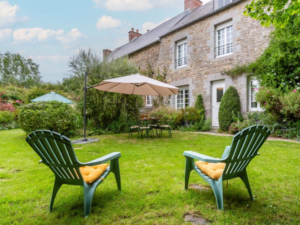 two chairs and an umbrella in the yard of a house at Holiday Home La Haute Gilberdière - SIY400 by Interhome in Sartilly