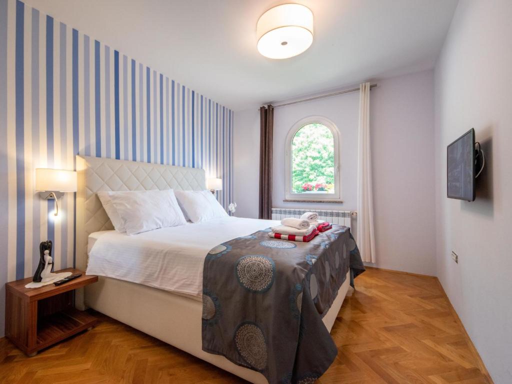a bedroom with a large bed and a window at Holiday Home Villa Orhidea by Interhome in (( Marčići ))