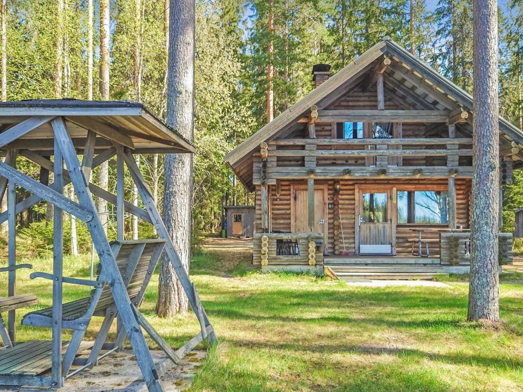 a log cabin in the woods with a swing at Holiday Home Kuusela by Interhome in Soini