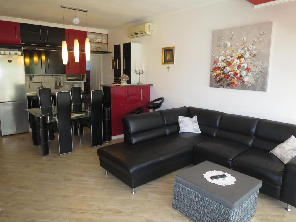 salon z czarną kanapą i kuchnią w obiekcie Apartment Mirjana-1 by Interhome w mieście Vrsi
