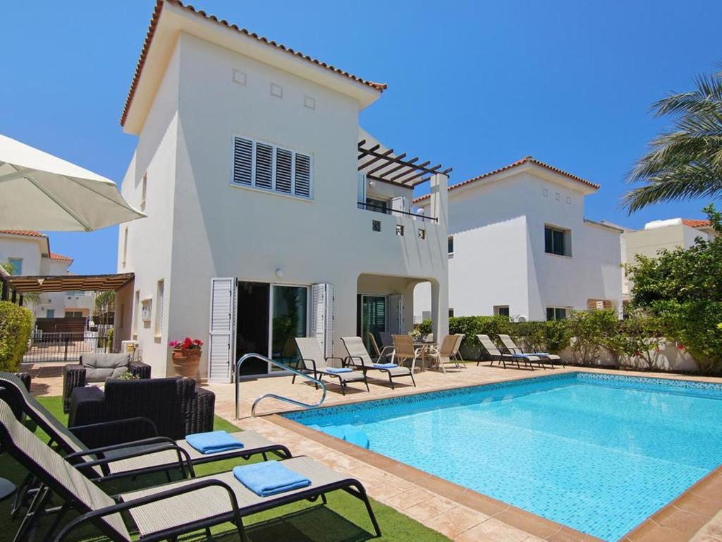 a villa with a swimming pool in front of a house at Villa palm by Interhome in Protaras