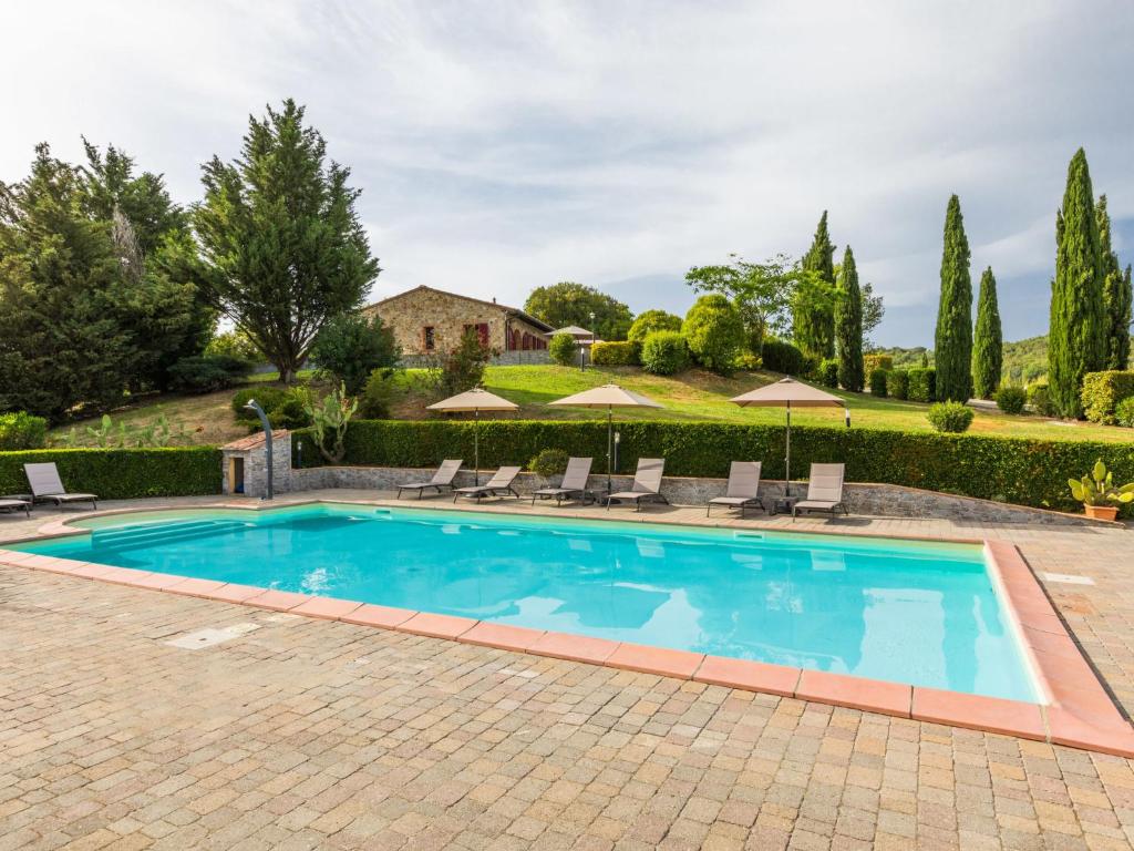 a pool with chairs and umbrellas in a yard at Holiday Home Girasole-2 by Interhome in Montecatini Val di Cecina