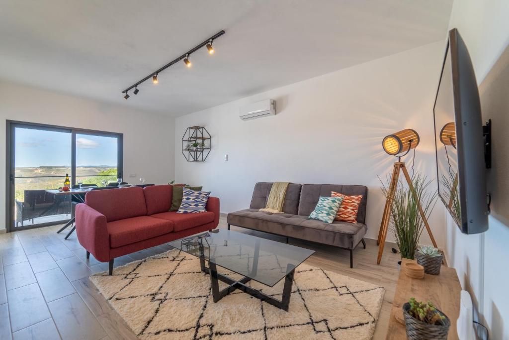 a living room with two couches and a tv at O MAÇARICO - Walking distance to Monte Clerigo and Amoreira beaches in Aljezur