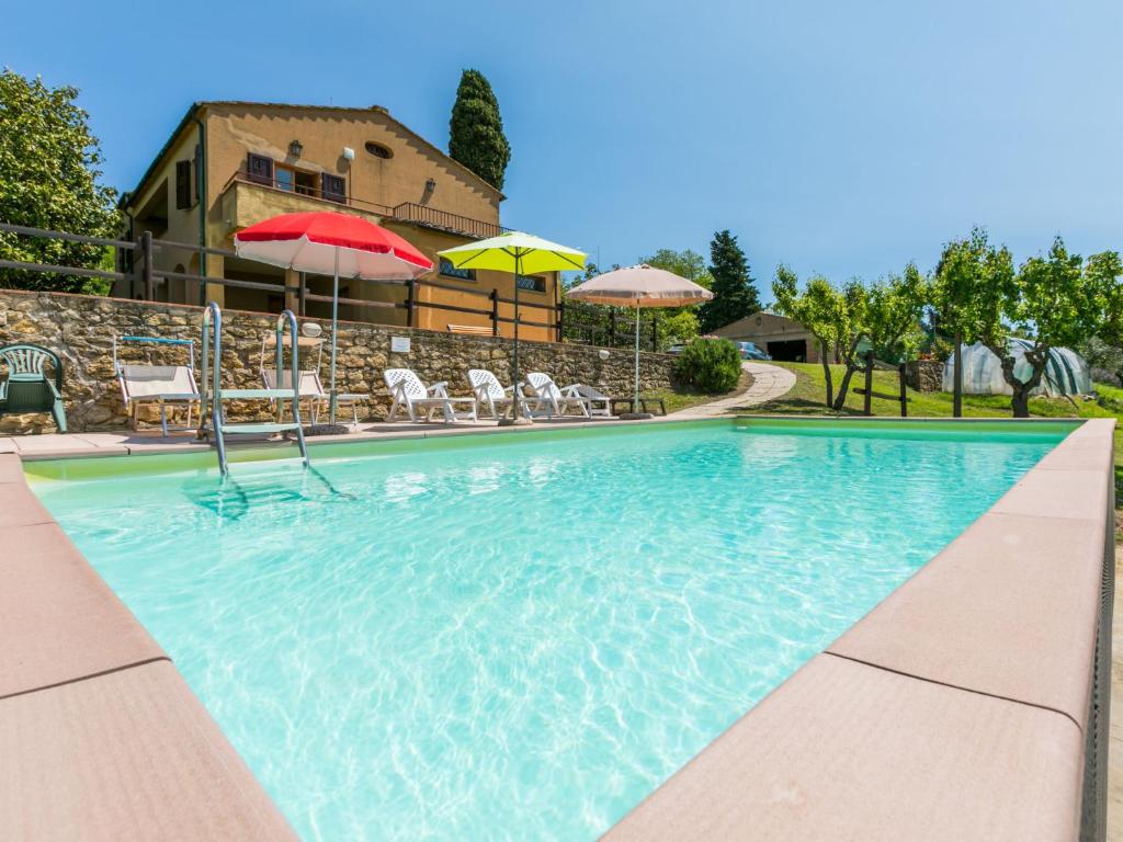 - une piscine avec des parasols, des tables et des chaises dans l'établissement Holiday Home Podere Santa Lucia by Interhome, à Volterra