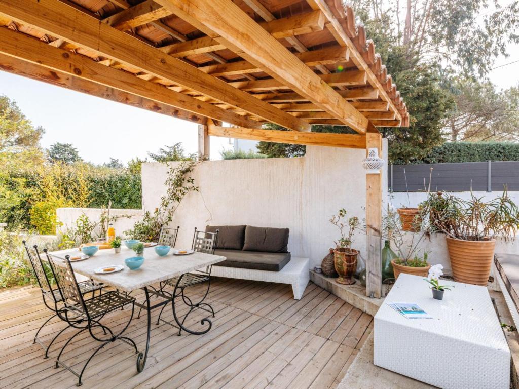 een patio met een tafel en een bank bij Holiday Home Maison Poincaré by Interhome in Saint-Aygulf