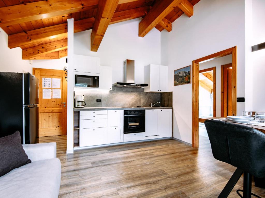 a kitchen with white cabinets and wooden ceilings at Apartment Cecilia-3 by Interhome in Campitello