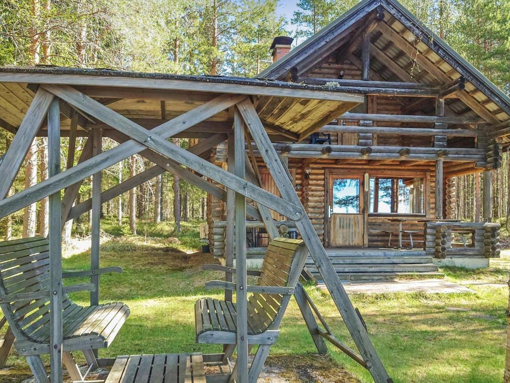 a log cabin with two chairs in front of it at Holiday Home Haapala by Interhome in Soini