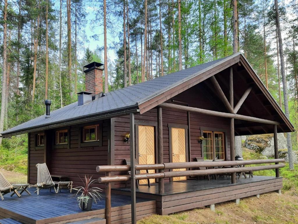 a log cabin with a deck and a chimney at Holiday Home Aili by Interhome in Arrakoski
