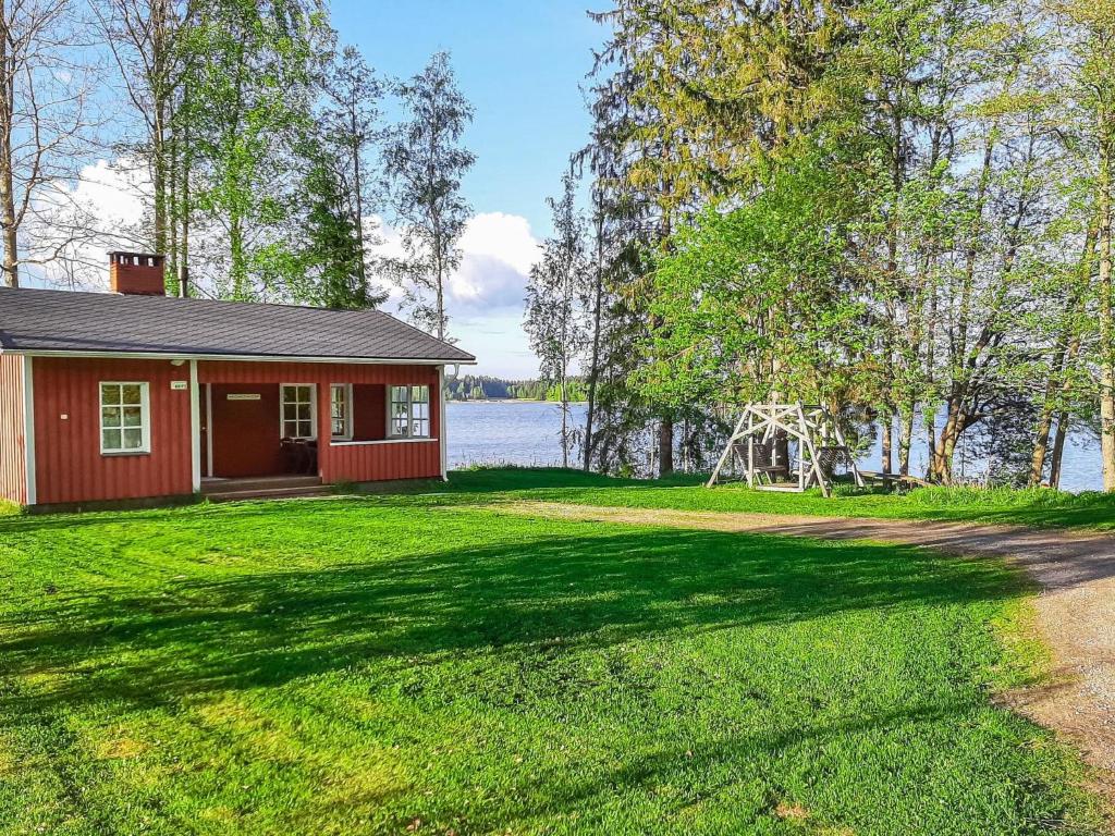 een klein rood huis aan de oever van een meer bij Holiday Home Haukiranta by Interhome in Kittilä