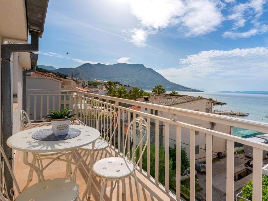 een balkon met een tafel en stoelen en de oceaan bij Apartment Niko 1 by Interhome in Duće
