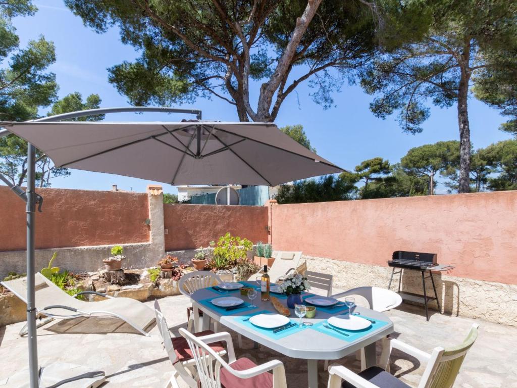 - une table et des chaises avec un parasol sur la terrasse dans l'établissement Apartment Anaisim by Interhome, à Saint-Cyr-sur-Mer
