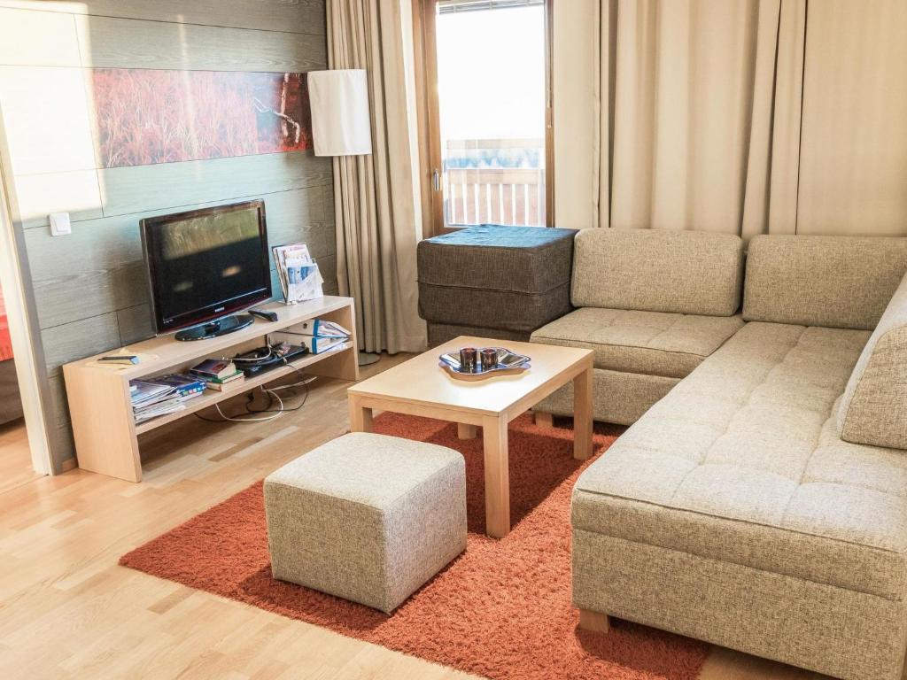 uma sala de estar com um sofá e uma televisão em Holiday Home Ski chalets 7204 by Interhome em Ylläsjärvi