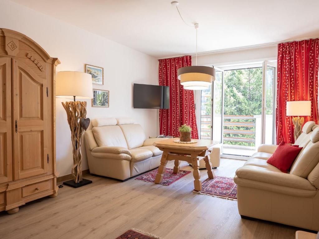 een woonkamer met een bank en een tafel bij Apartment Chesa Derby 27 by Interhome in St. Moritz