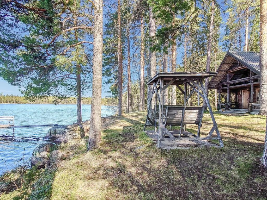un banco en un cenador junto a un lago en Holiday Home Mäntylä by Interhome, en Soini