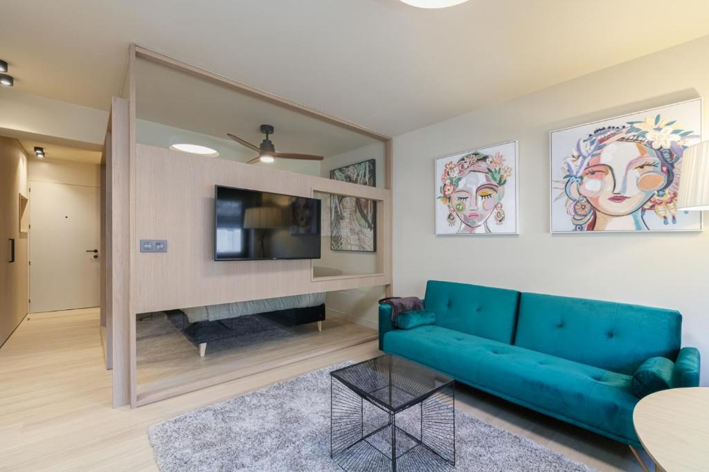 sala de estar con sofá azul y TV en SUITE DE LUJO PUERTA DEL SOL+Parking, en Vigo