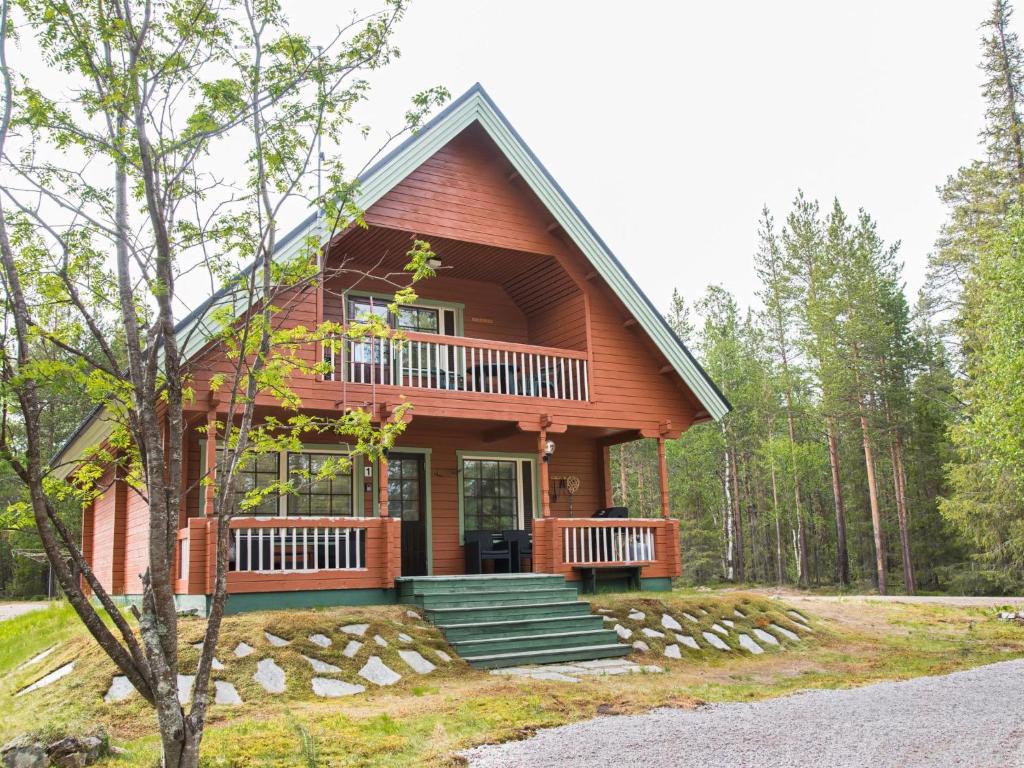 a cabin in the woods with a wrap around porch at Holiday Home Lomamaja 1 by Interhome in Raattama