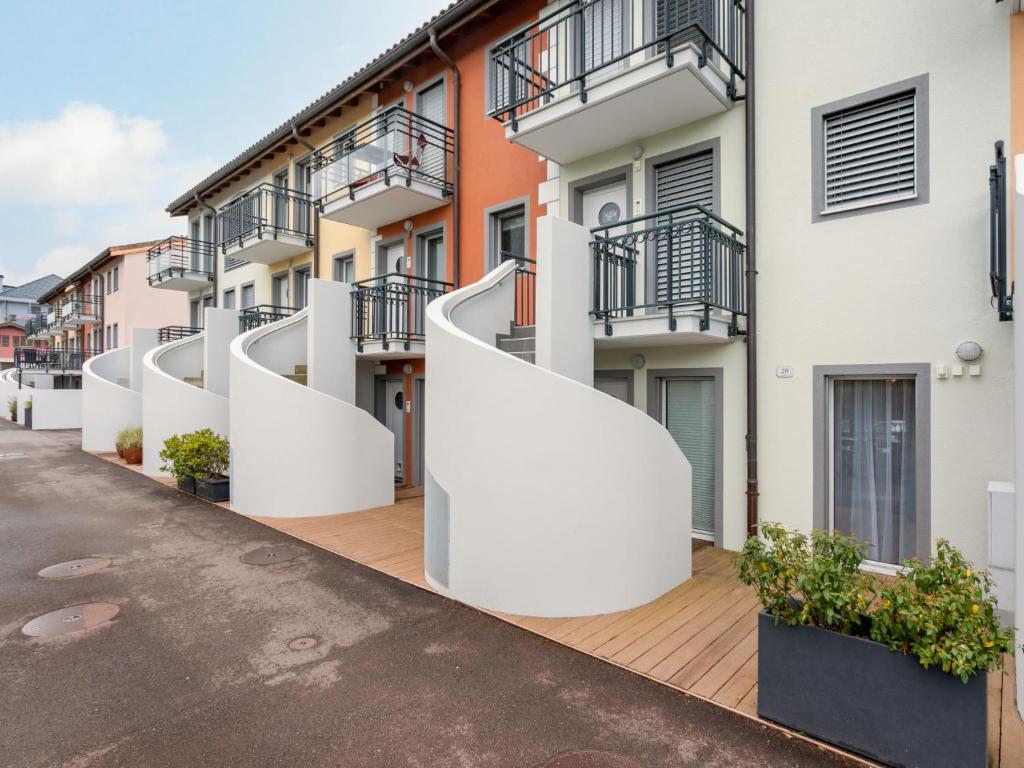 Apartment Tasman S20-R by Interhome في بوفيريه: صف من مباني الشقق البيضاء ذات السلالم البيضاء