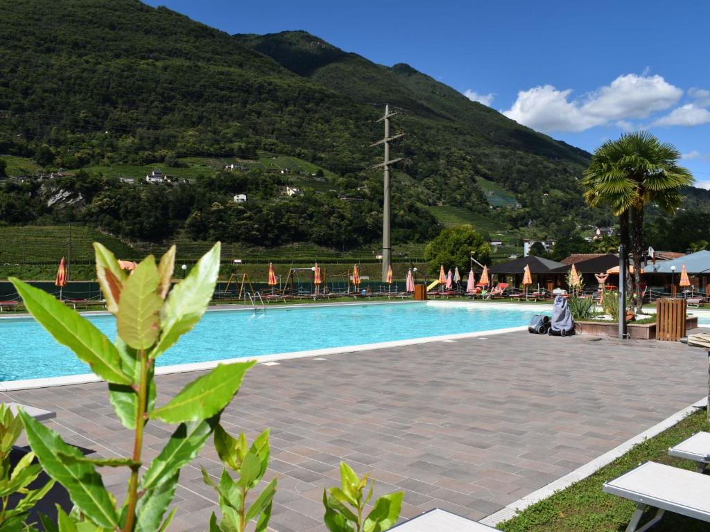 ein Schwimmbad mit einem Berg im Hintergrund in der Unterkunft Holiday Home Bungalow Isola Premium by Interhome in Gudo