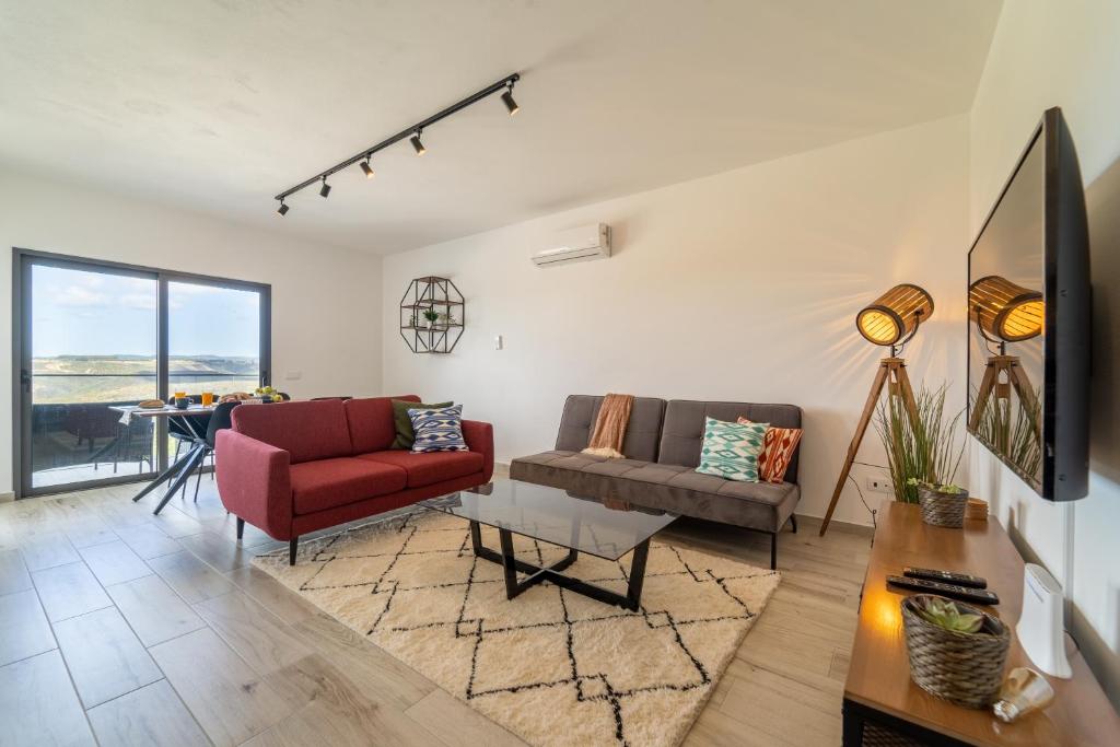 Una sala de estar con dos sofás y una mesa. en A TARAMBOLA - Walking distance to Monte Clerigo and Amoreira beaches, en Aljezur
