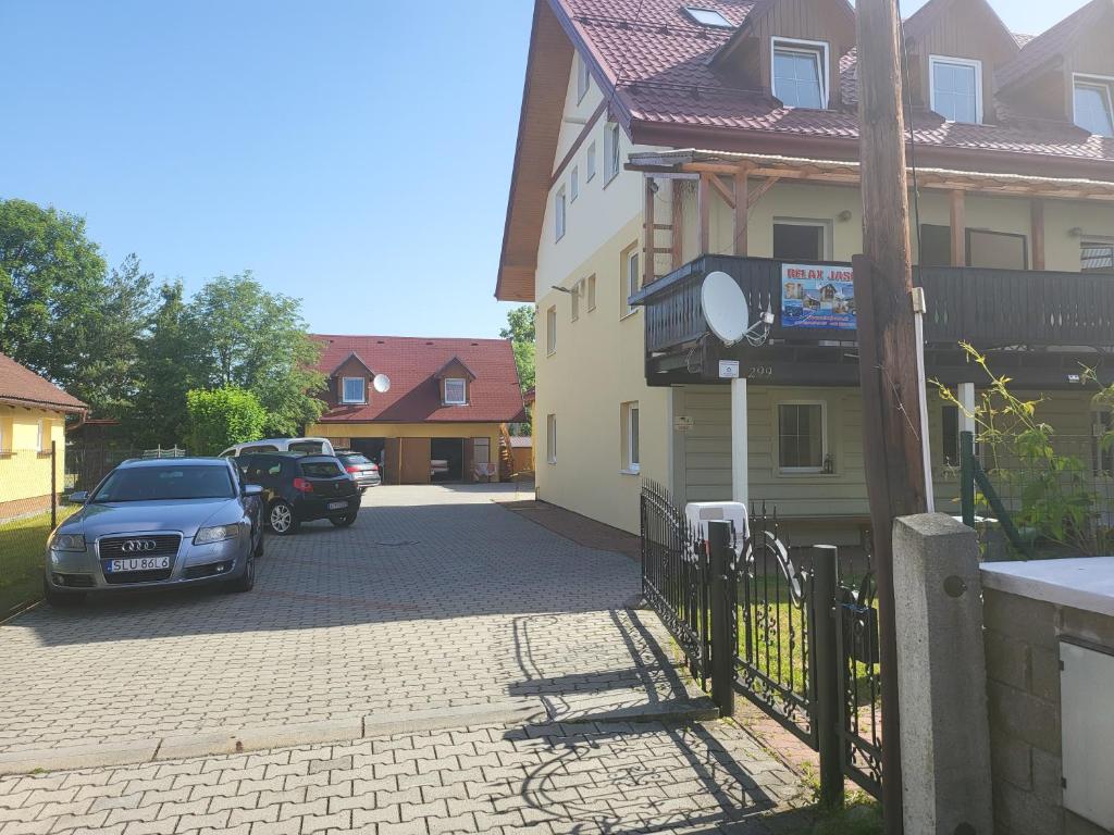 a car parked next to a house with a fence at Relax Jasna in Liptovský Mikuláš