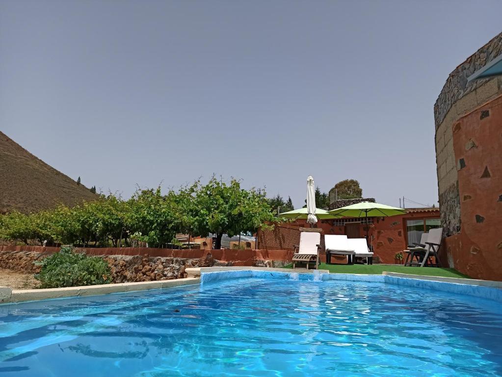 une grande piscine bleue à côté d'un bâtiment dans l'établissement Casa de los abuelos, à Vilaflor