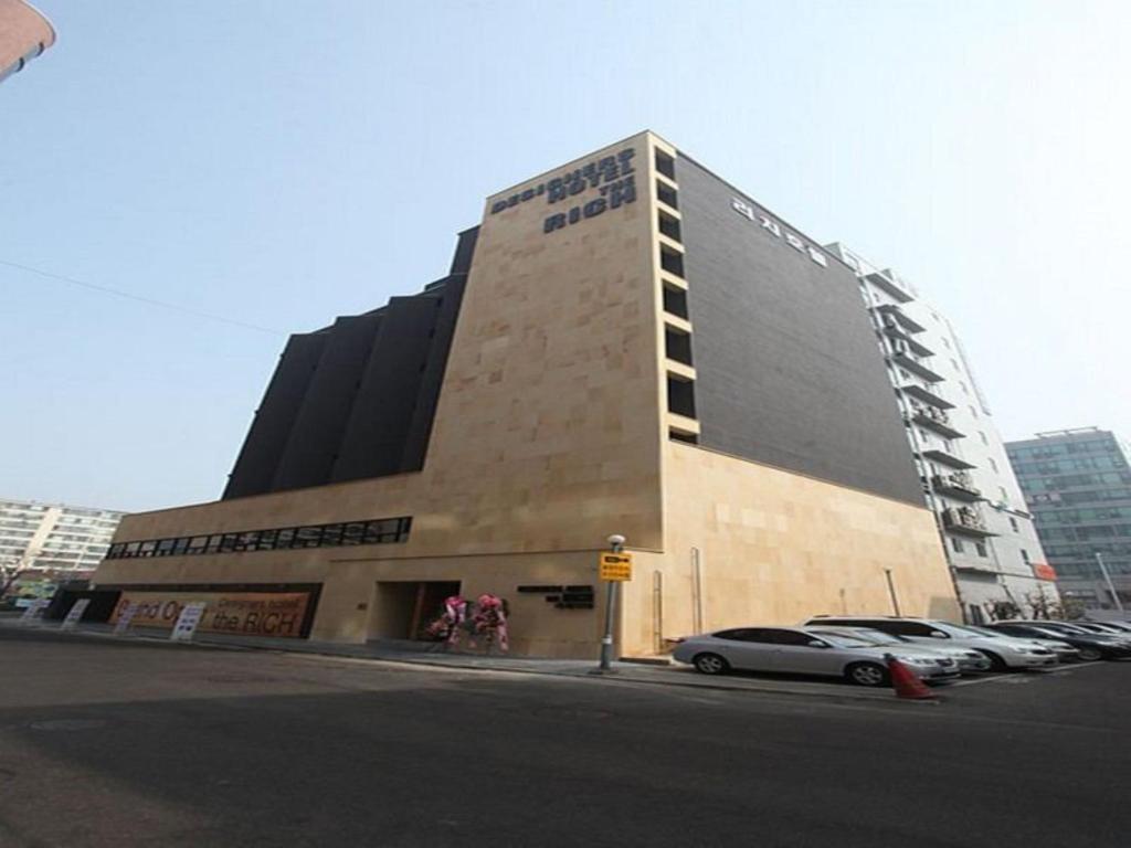 a large building with cars parked in front of it at Hotel Rich in Goyang