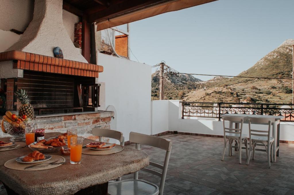 einen Tisch und Stühle auf einer Terrasse mit Kamin in der Unterkunft Chaniotis Home, In the heart of Kinidaros in Kinídharos