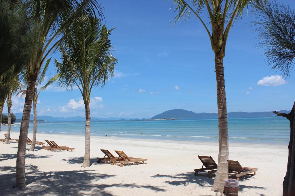 - une plage avec des chaises, des palmiers et l'océan dans l'établissement GM Doc Let Beach Resort & Spa, à Doc Let