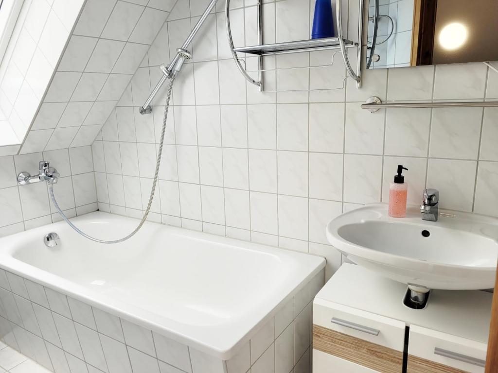 a white bathroom with a sink and a tub and a toilet at Pension Landhaus Teichgraf in Wolgast