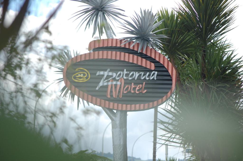 a sign for a restaurant in front of palm trees at Rotorua Motel in Rotorua