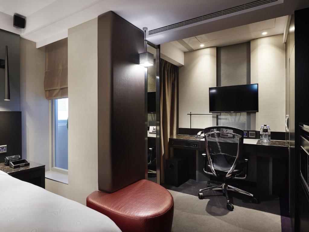 a hotel room with a desk and a chair at The Tango Hotel Taipei FuHsing in Taipei