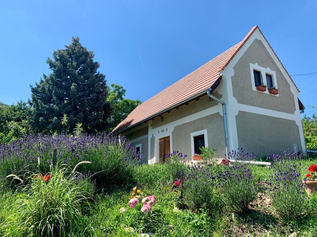 ein kleines Haus mit Blumen davor in der Unterkunft Balaton home with a majestic view in Balatonederics