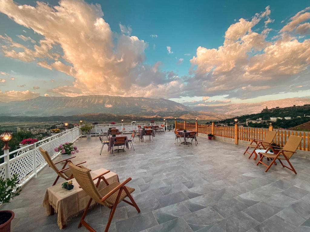 eine Terrasse mit Tischen und Stühlen auf dem Balkon in der Unterkunft Guest House Juald in Gjirokastër
