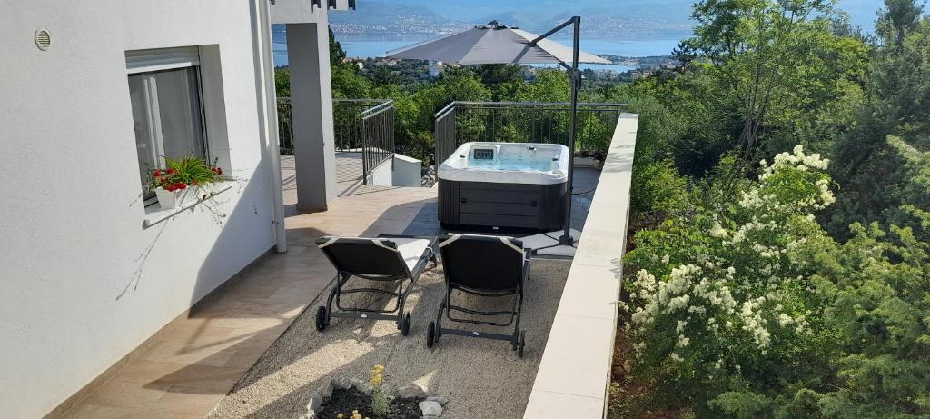 a patio with two chairs and a grill on a house at Apartment Sunrise, Polje - otok Krk in Polje