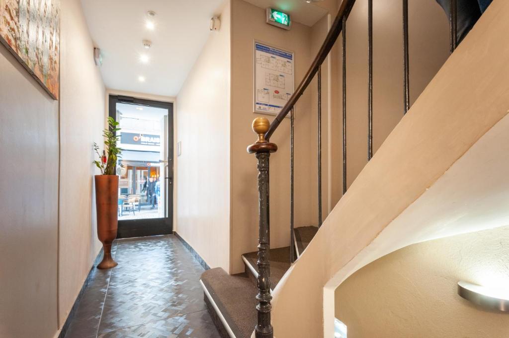 a hallway with a staircase and a stair case at Hotel l'Hotera in Cannes